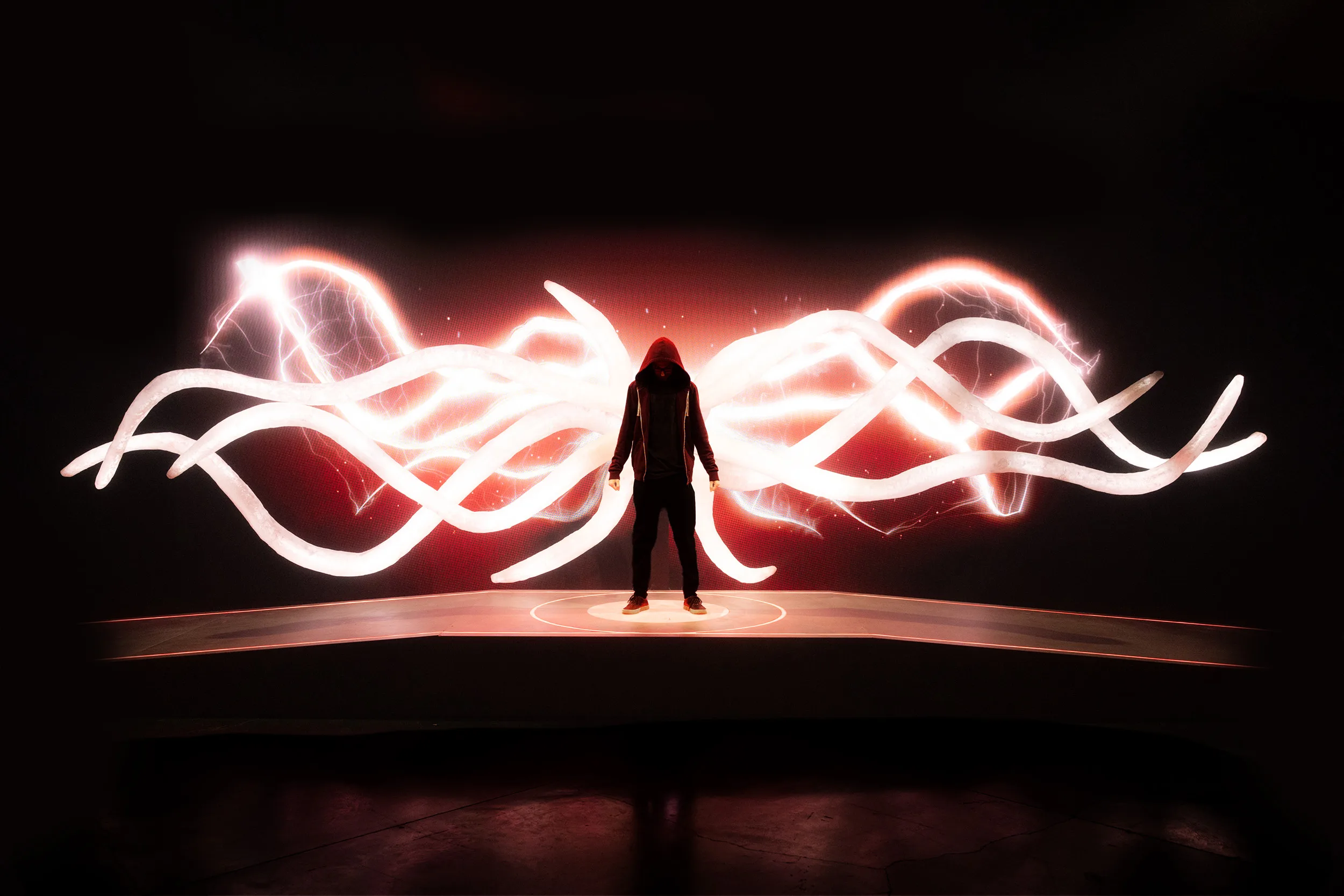 Light-painted wings around a hooded figure on the BlizzCon main stage