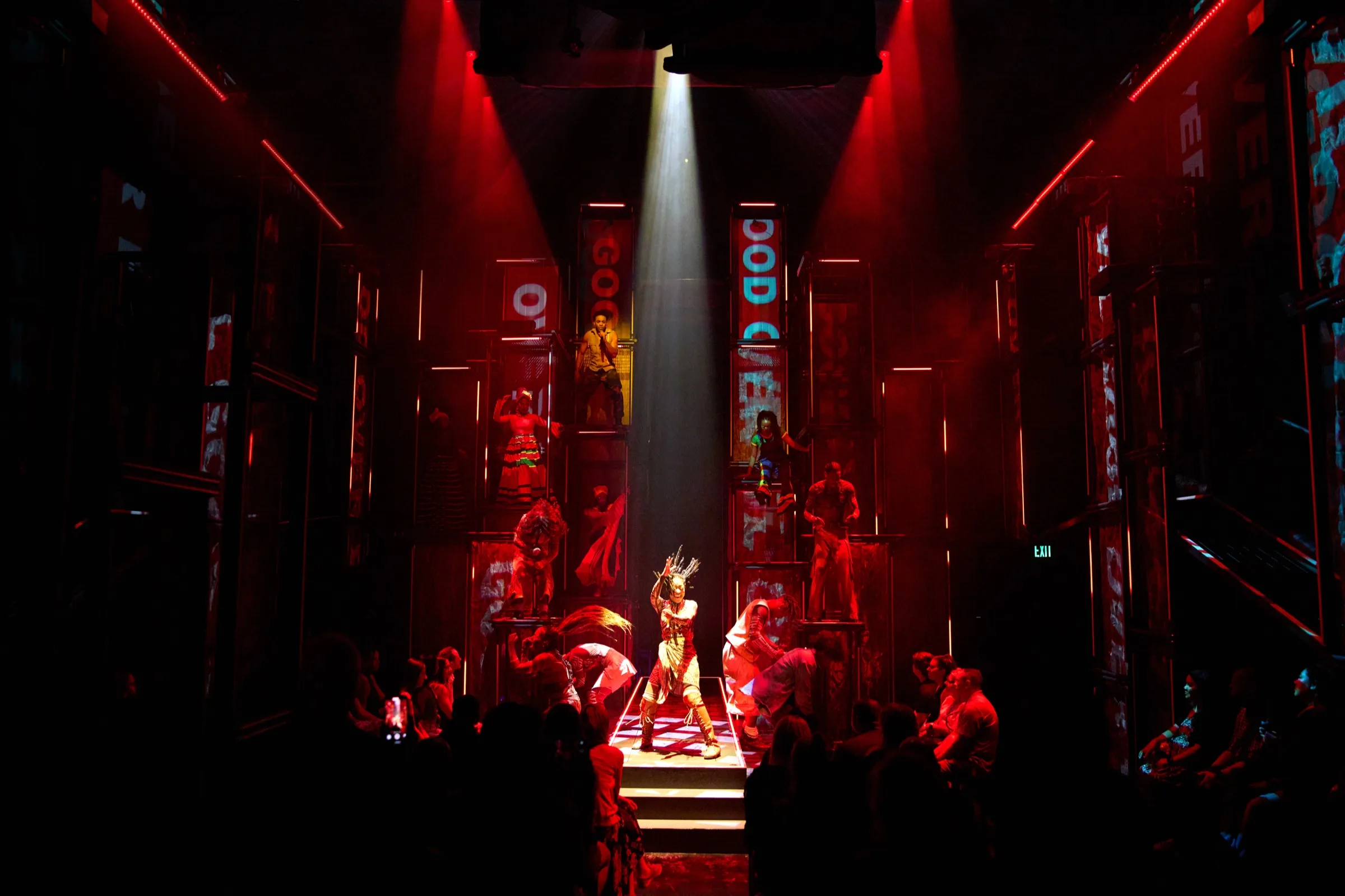 Red corridor scene with a spotlit dancer between panels