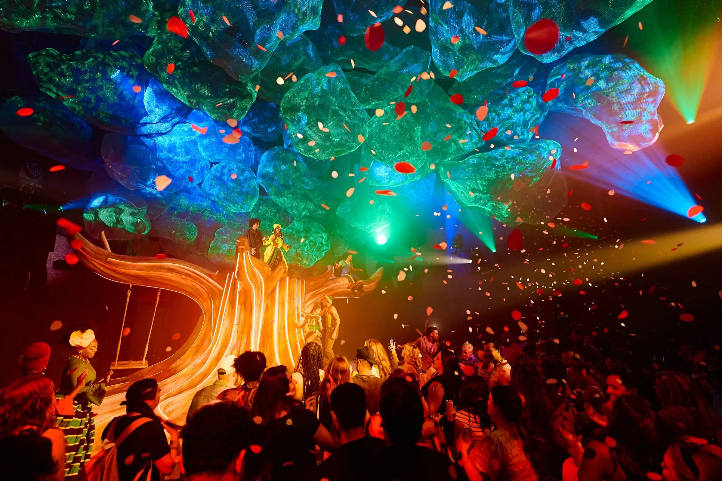 The glowing tree canopy set piece over an immersed audience