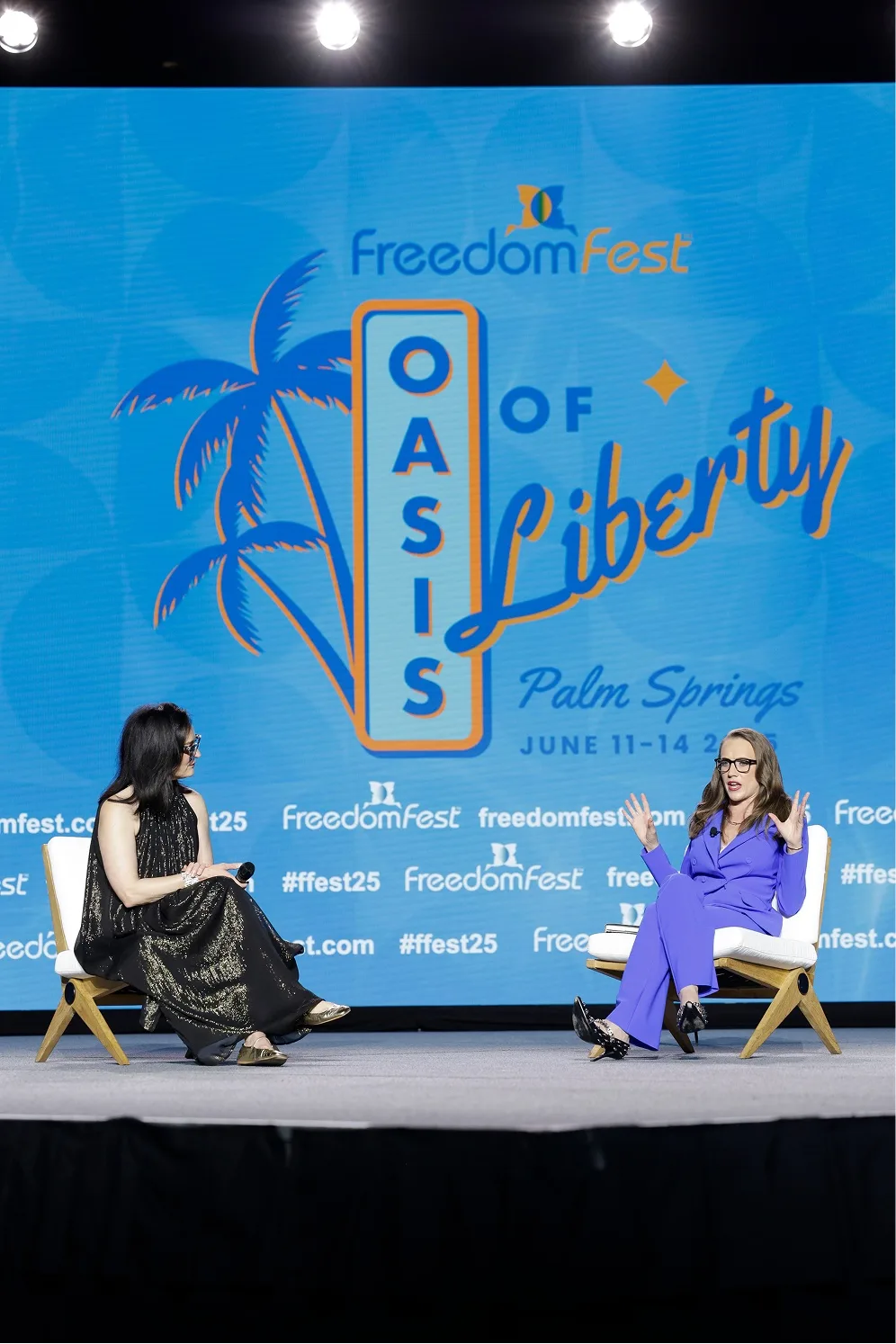 Speakers on stage against the blue event identity backdrop