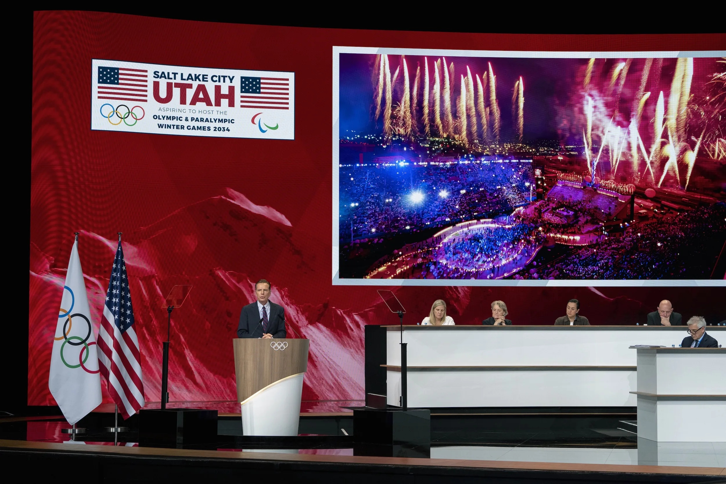 The bid presentation on the session LED wall behind the podium