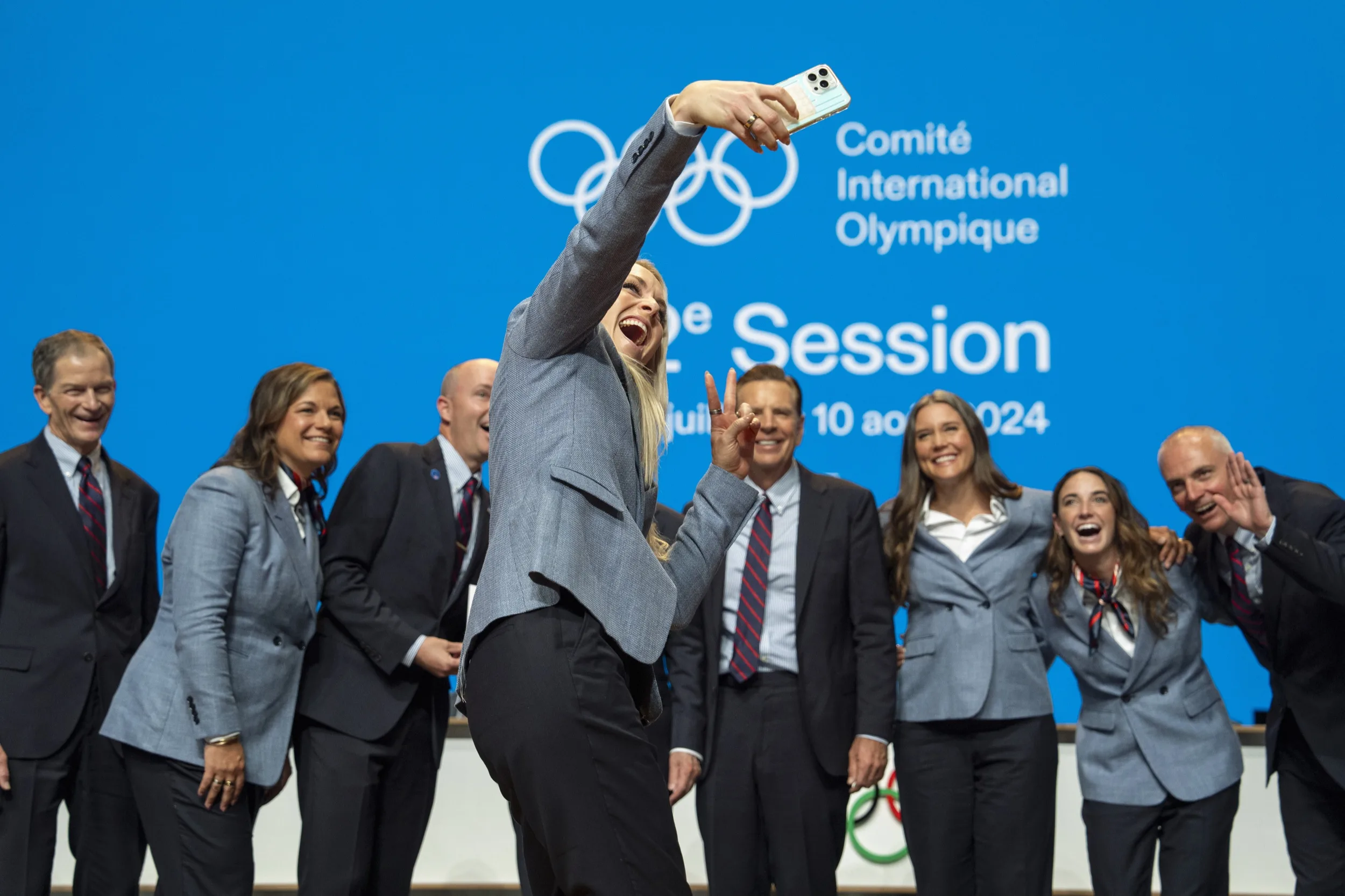 The delegation celebrates with a group selfie at the IOC session